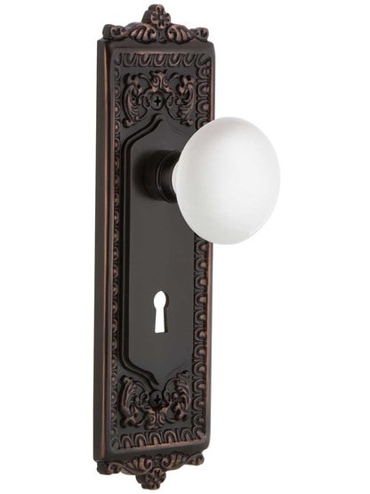 Egg and Dart Design Mortise Lock Set With White Porcelain Door Knobs in Timeless Bronze.